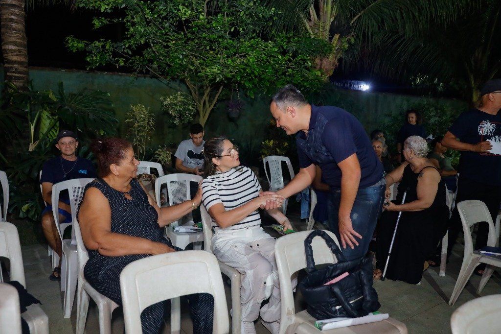 Professor Anderson cumprimentando moradora em reunião comunitária